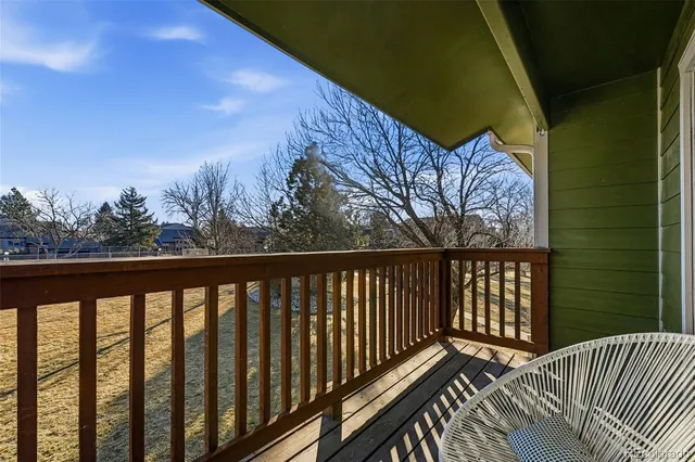 a balcony with wooden floor and fence