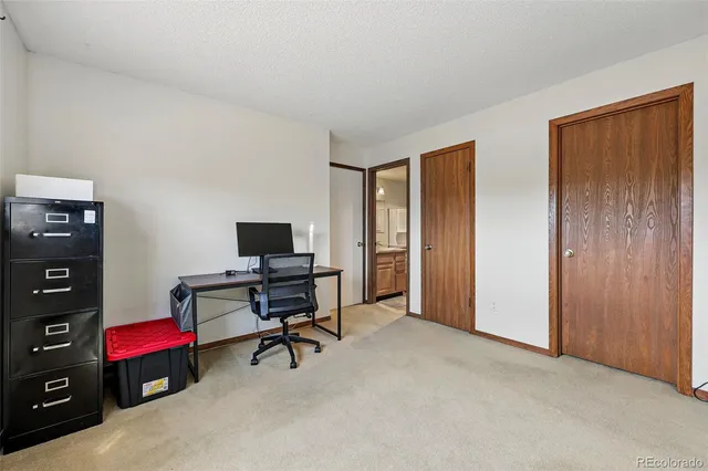 a view of a workspace with furniture and a window