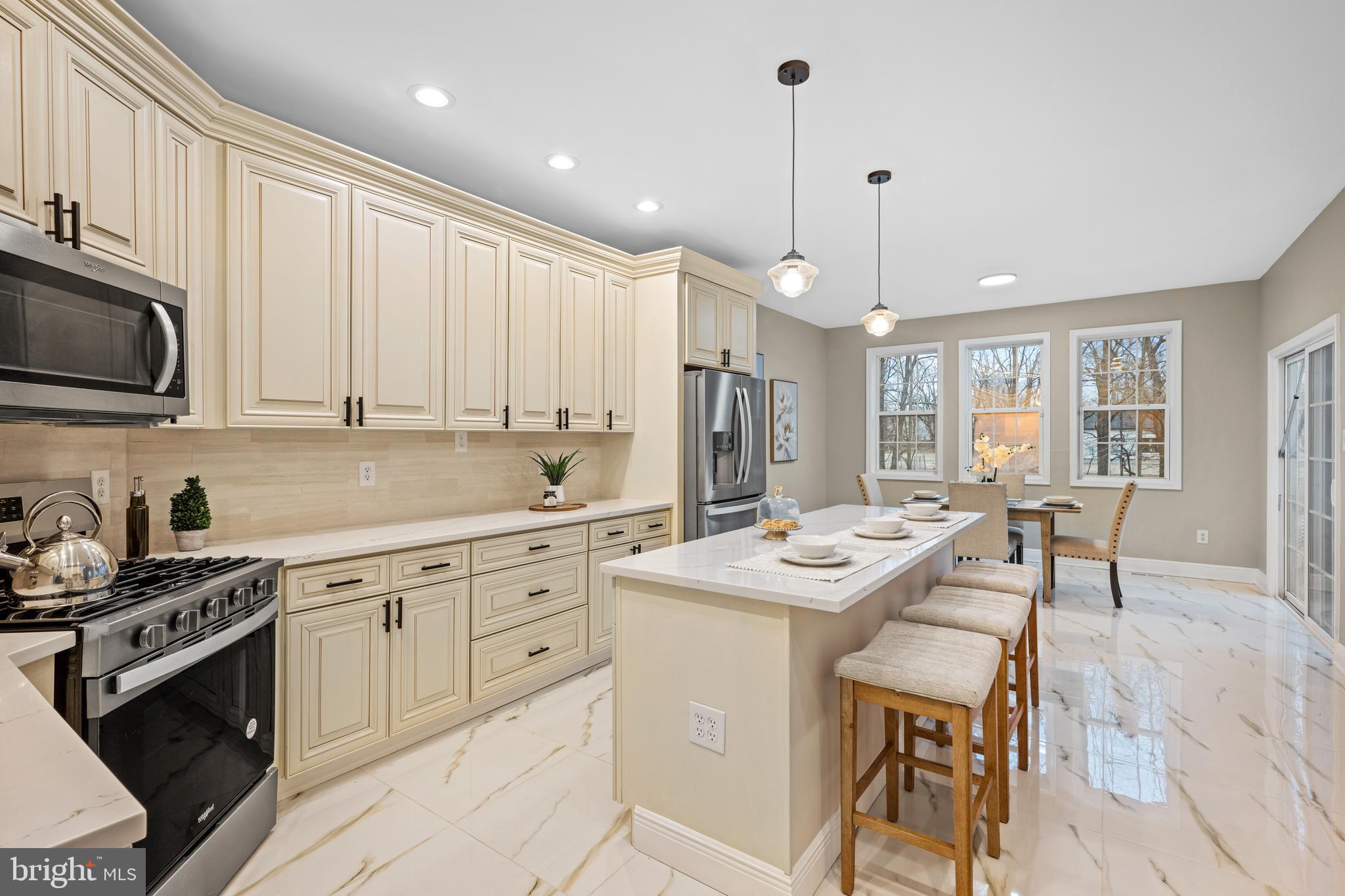 6 River Run Lawnside, NJ 08045 - Photo 16 of 64 a kitchen with kitchen island white cabinets a sink a stove a dining table and chairs