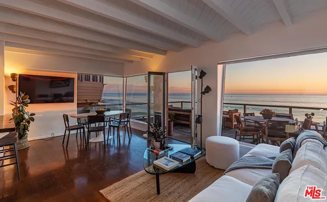 a living room with furniture floor to ceiling window and wooden floor