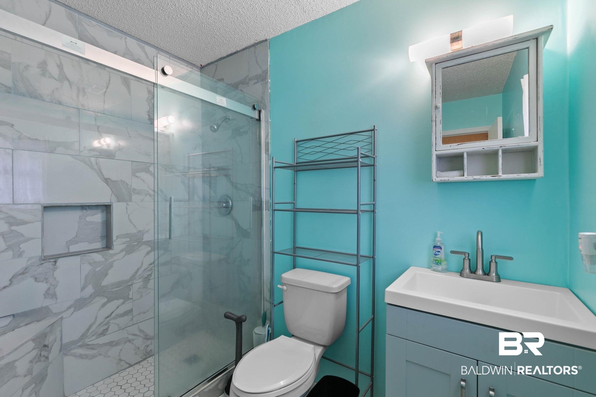 13653 Roberts Road Loxley, AL 36551 - Photo 25 of 33 Contemporary bathroom featuring a spacious shower with glass enclosure, large format marble-look tile, and a built-in shower niche