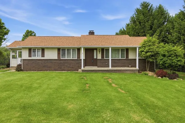 a view of an house with backyard space and balcony