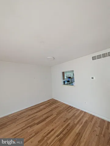 a view of a room with wooden floor and window