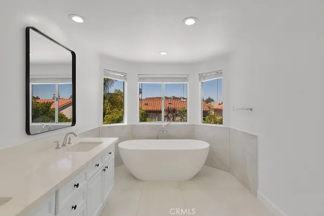 a spacious bathroom with a large tub sink and mirror