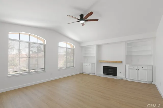 a view of empty room with fan and windows