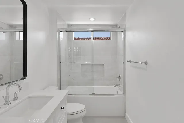 a bathroom with a bathtub shower sink vanity and toilet