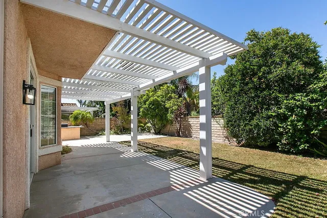 a view of a patio with table and chairs and wooden fence