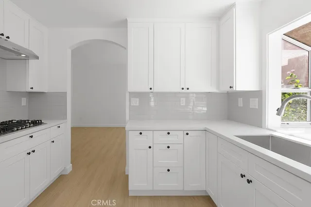 a kitchen with granite countertop white cabinets and a stove