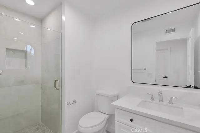 a bathroom with a sink vanity mirror and toilet