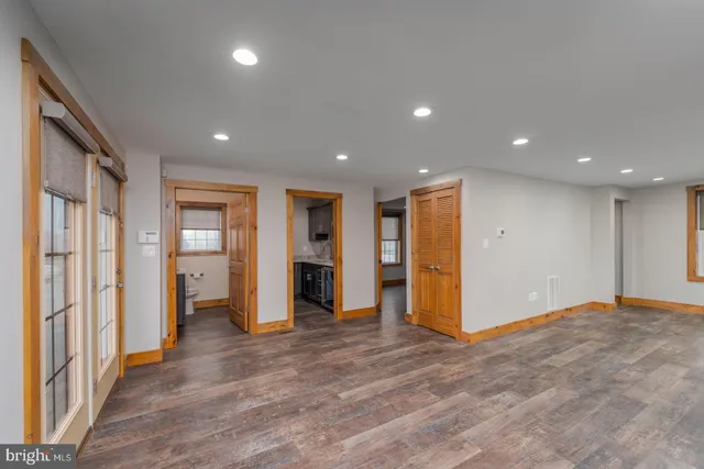 a view of an empty room with closet and wooden floor