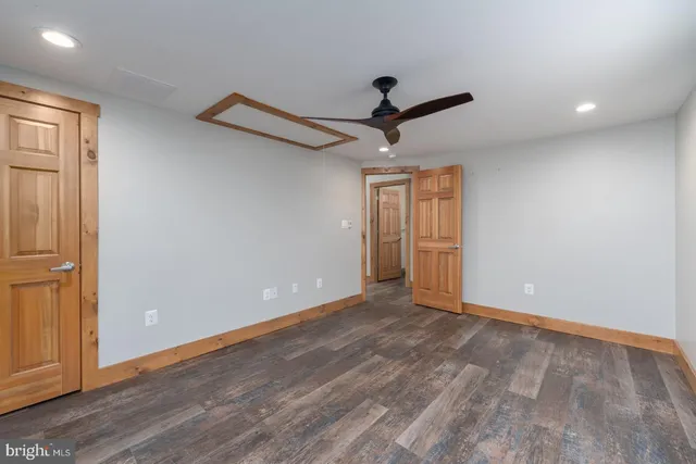 a view of room with wooden floor and ceiling fan