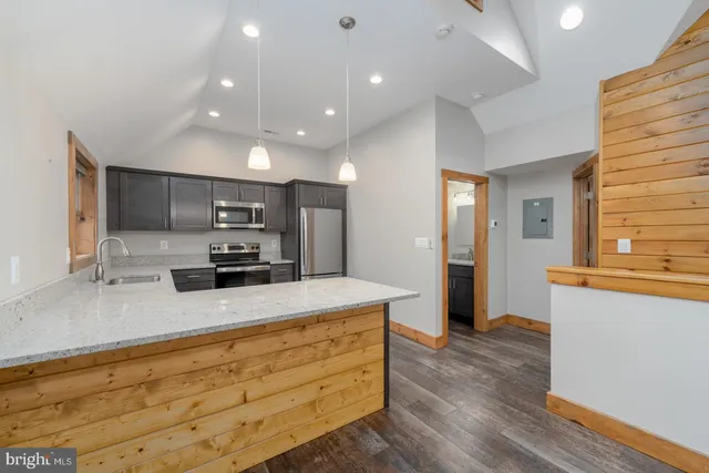 a large kitchen with kitchen island a sink stainless steel appliances and cabinets
