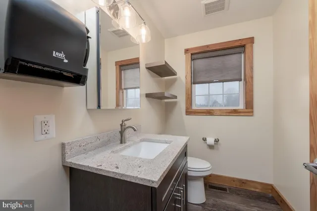 a bathroom with a toilet a sink and mirror