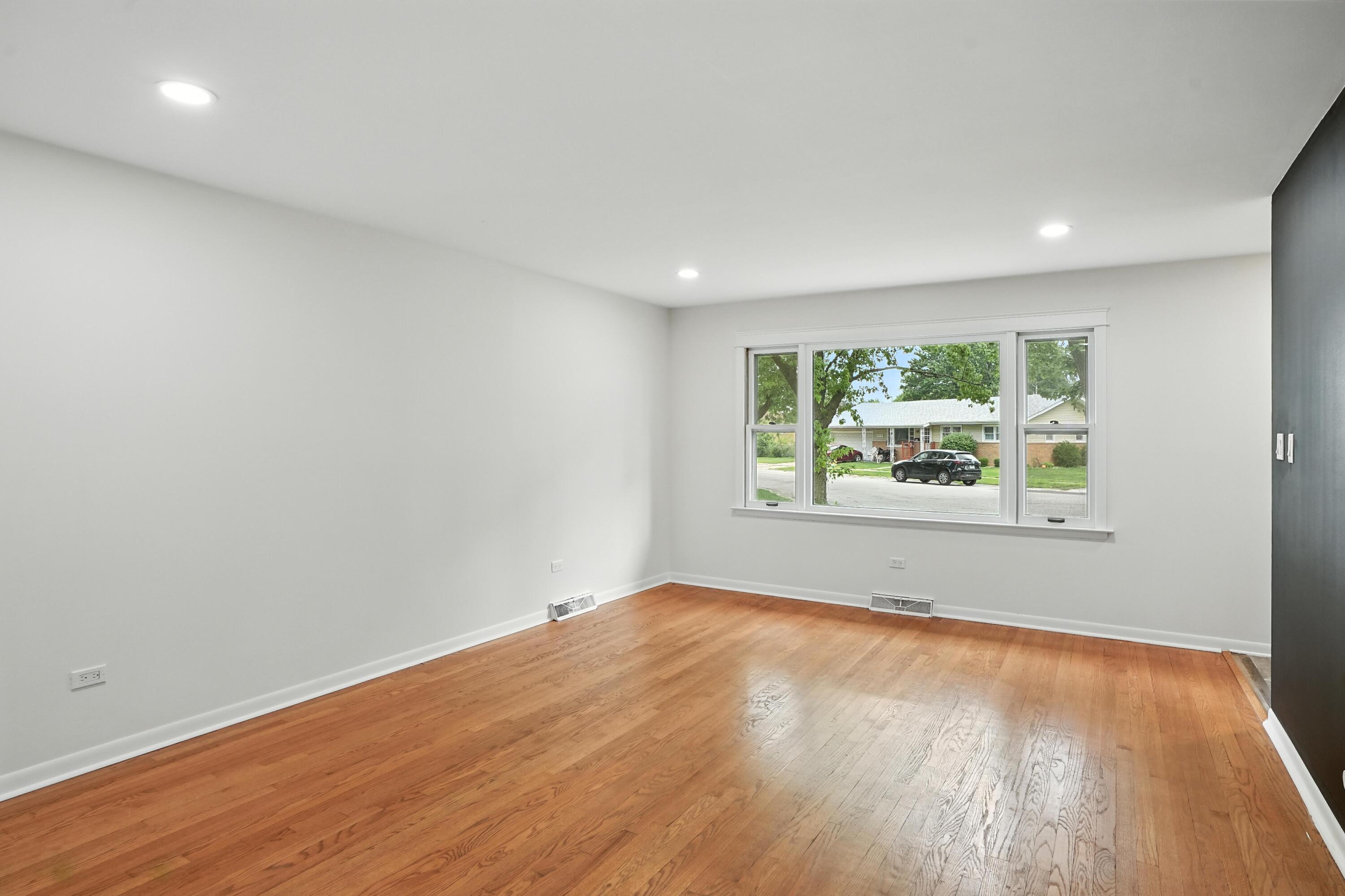 3312 East 170th Street Lansing, IL 60438 - Photo 12 of 38 an empty room with wooden floor and windows