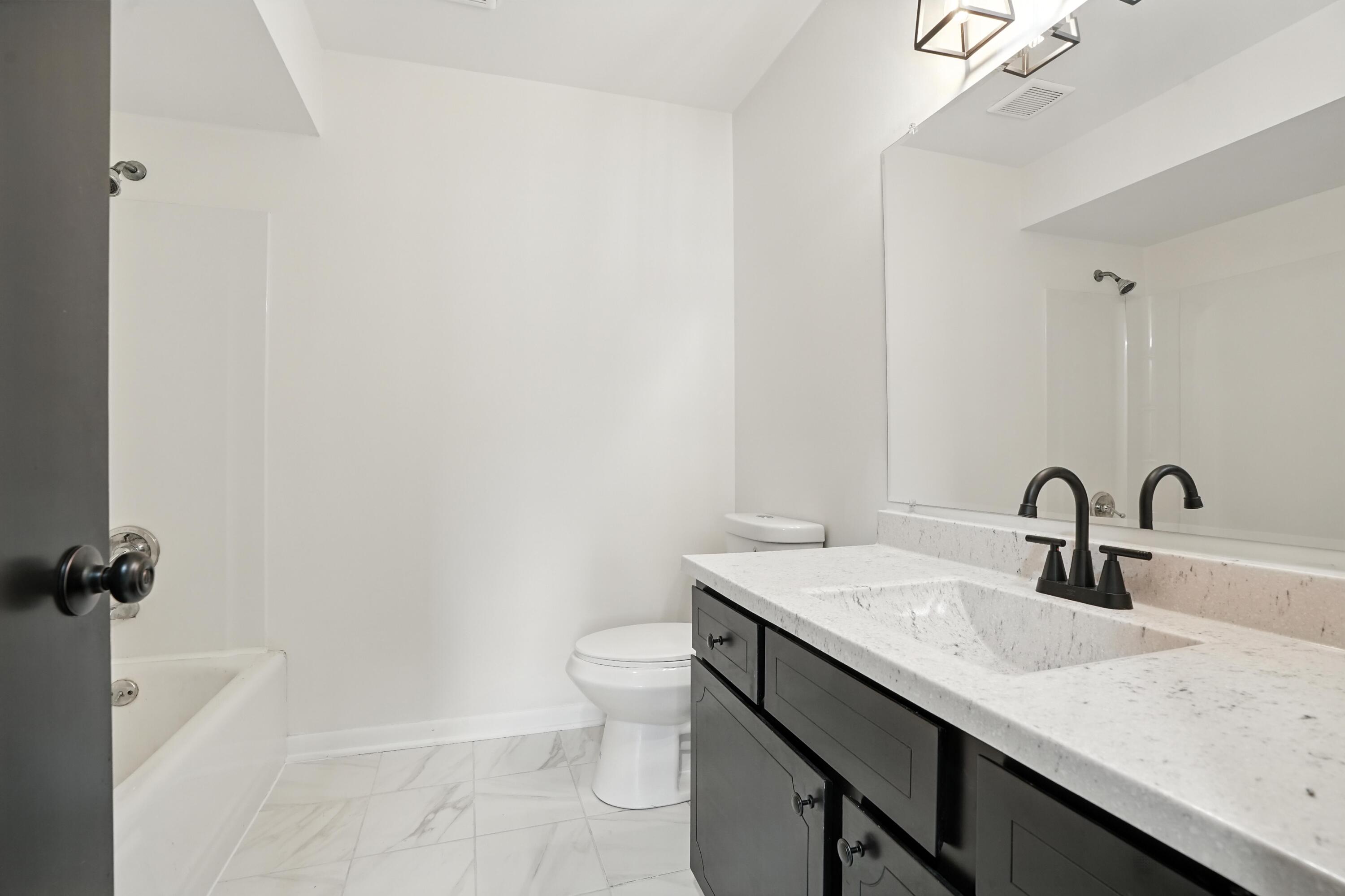 3312 East 170th Street Lansing, IL 60438 - Photo 24 of 38 a bathroom with a granite countertop sink a toilet and a bathtub