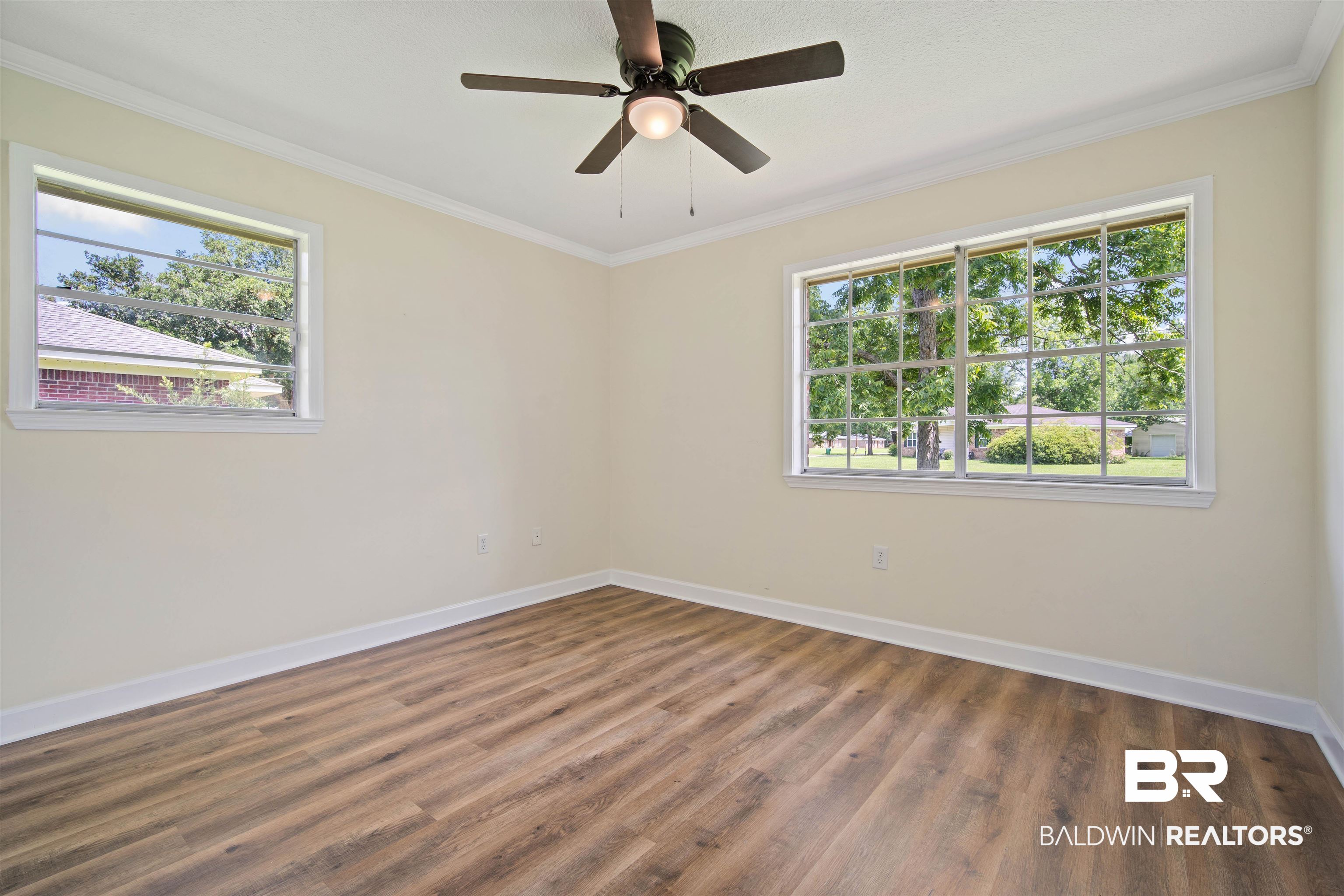 1325 Pawnee Circle Saraland, AL 36571 - Photo 15 of 26 Empty room featuring wood finished floors, crown molding, and a ceiling fan