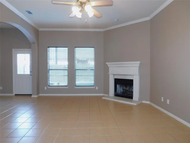 an empty room with windows and fireplace
