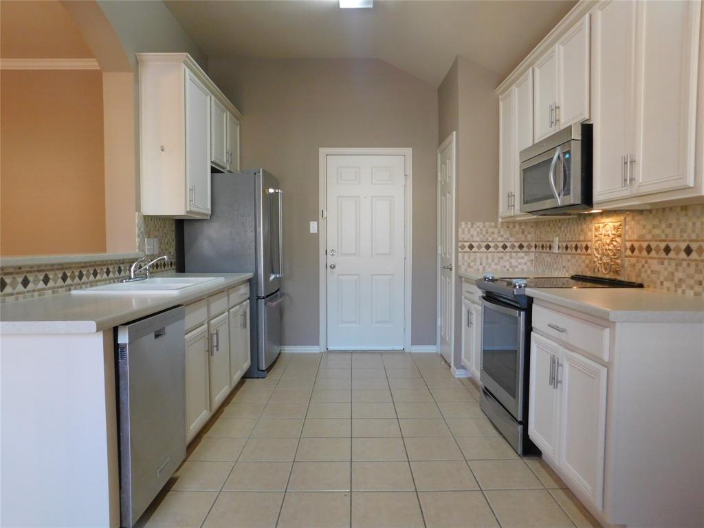 3919 Canton Court Denton, TX 76208 - Photo 10 of 26 a kitchen with stainless steel appliances granite countertop a refrigerator and a stove
