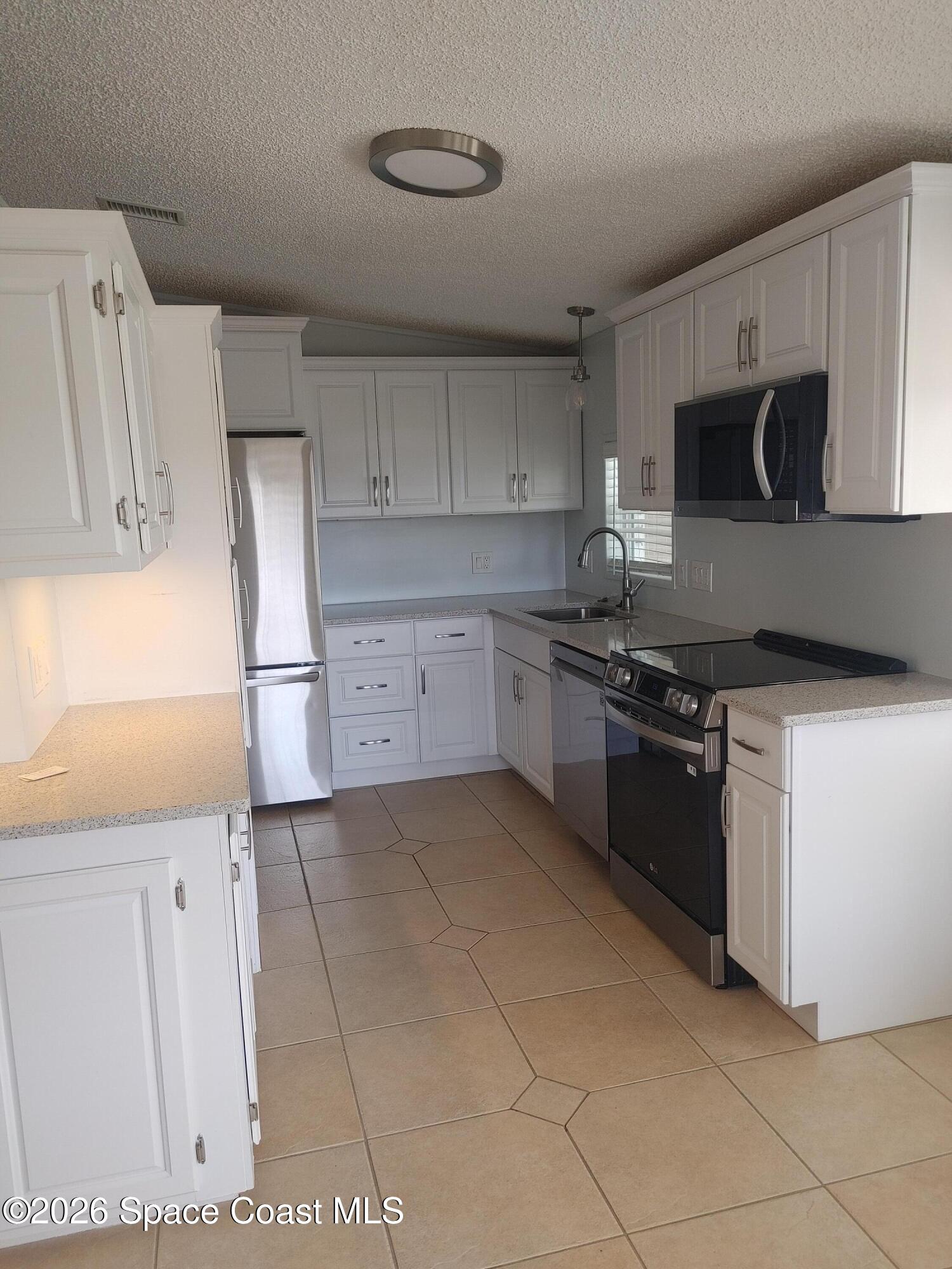 7629 Chasta Road Micco, FL 32976 - Photo 10 of 16 a kitchen with stainless steel appliances granite countertop a refrigerator and a stove top oven