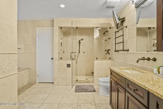 a bathroom with a tub shower sink and mirror