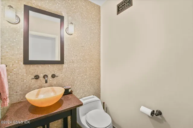 a bathroom with a toilet sink and mirror