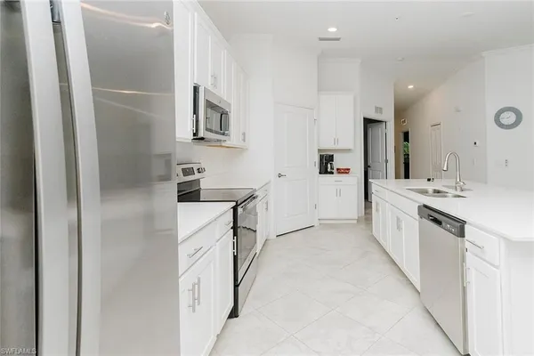 a large white kitchen with stainless steel appliances
