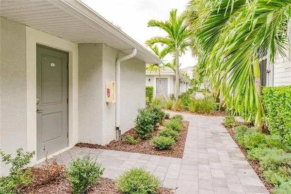 a front view of a house with a yard and potted plants