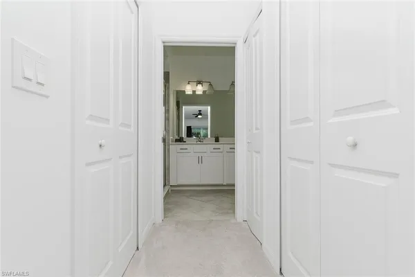 a view of a hallway with a white cabinet and a sink