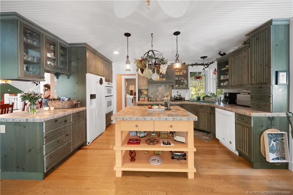 12 Oak Hill Way Stuart, FL 34996 - Photo 18 of 63 a large kitchen with stainless steel appliances kitchen island granite countertop a table chairs in it and a view of living room