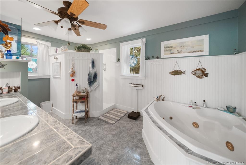 12 Oak Hill Way Stuart, FL 34996 - Photo 30 of 63 a bathroom with a tub a sink and a shower