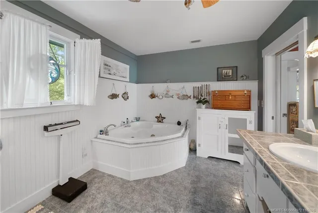 a bathroom with a sink a toilet a mirror and shower curtain