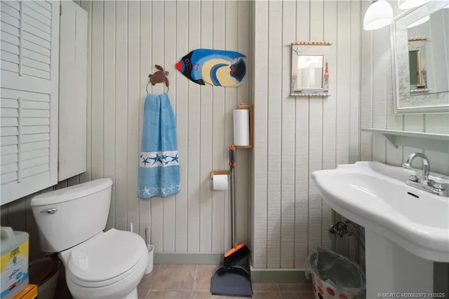 a white toilet sitting next to a bathroom sink and a tub