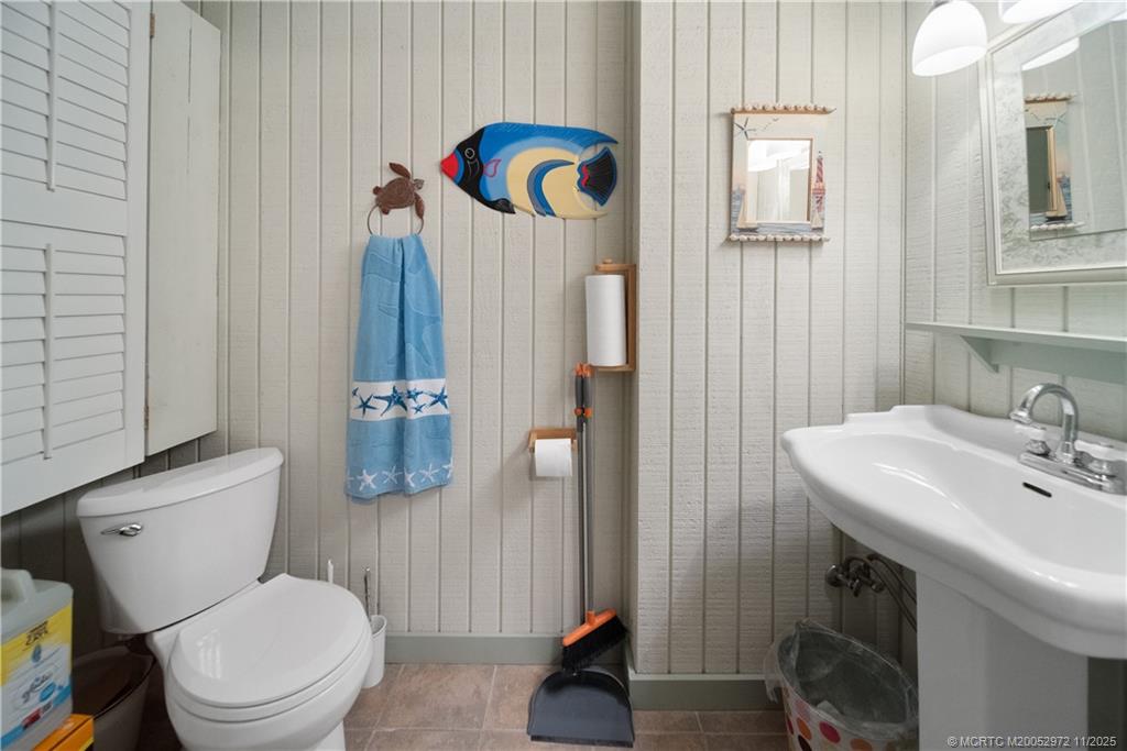 12 Oak Hill Way Stuart, FL 34996 - Photo 37 of 63 a bathroom with a sink a toilet a mirror and shower curtain