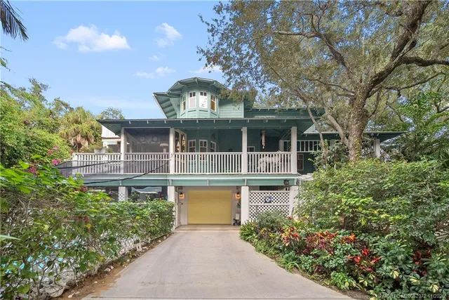 a front view of a house with a garden and trees