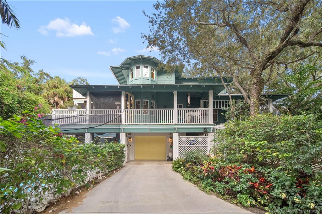 12 Oak Hill Way Stuart, FL 34996 - Photo 5 of 63 a front view of a house with a garden and trees