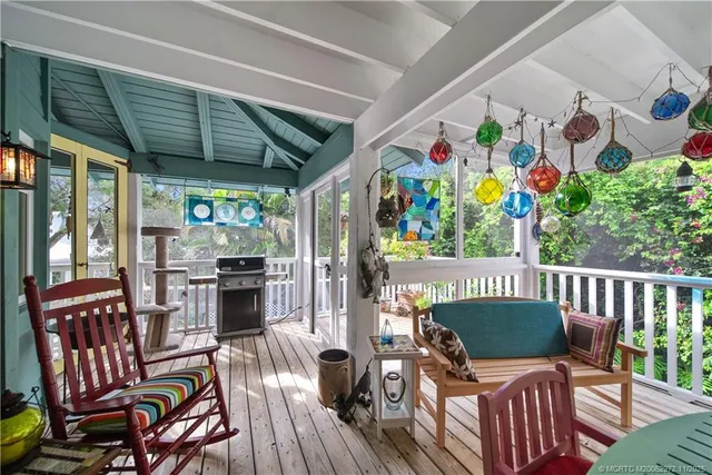 a kitchen with stainless steel appliances kitchen island granite countertop a refrigerator a stove top oven and couches with wooden floor