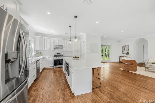 1 Kewanee Road New Rochelle, NY 10804 - Photo 9 of 36 a white kitchen with wooden floor and stainless steel appliances