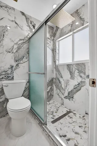 a bathroom with a toilet and a shower