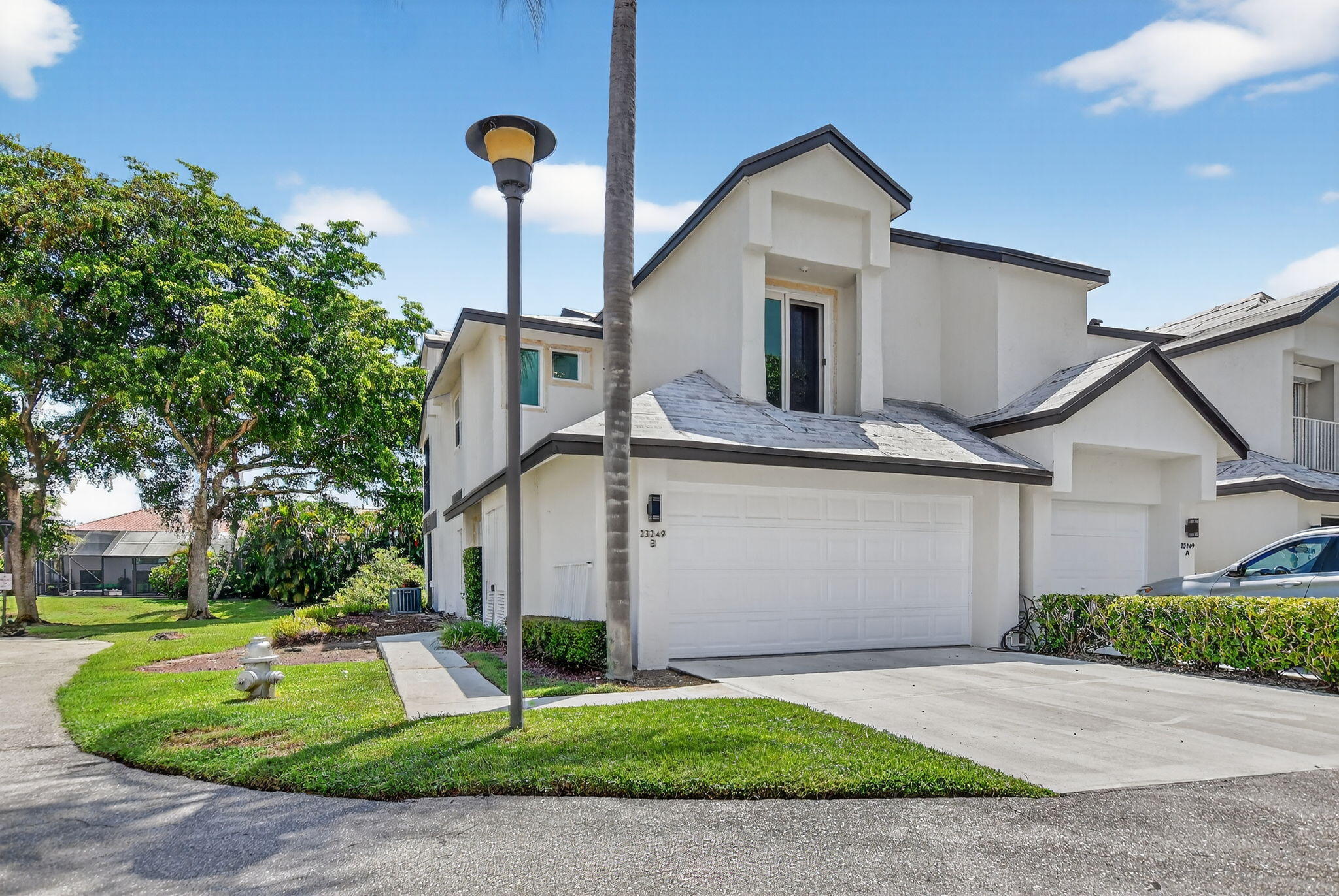 23181 Fountain View Drive, Unit B Boca Raton, FL 33433 - Photo 19 of 21 a front view of a house with a yard and garage