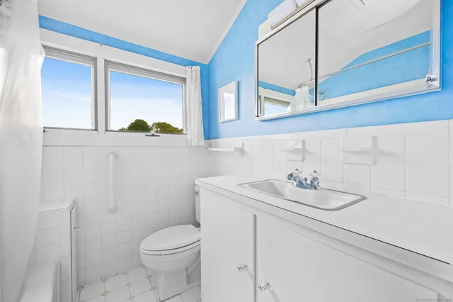 a bathroom with a toilet sink and mirror