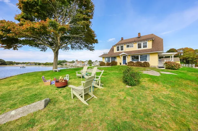 a view of a house with a yard table and chairs