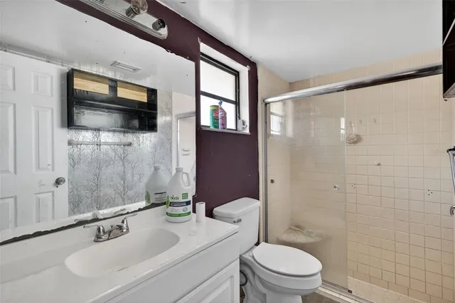 a bathroom with a sink a toilet and shower