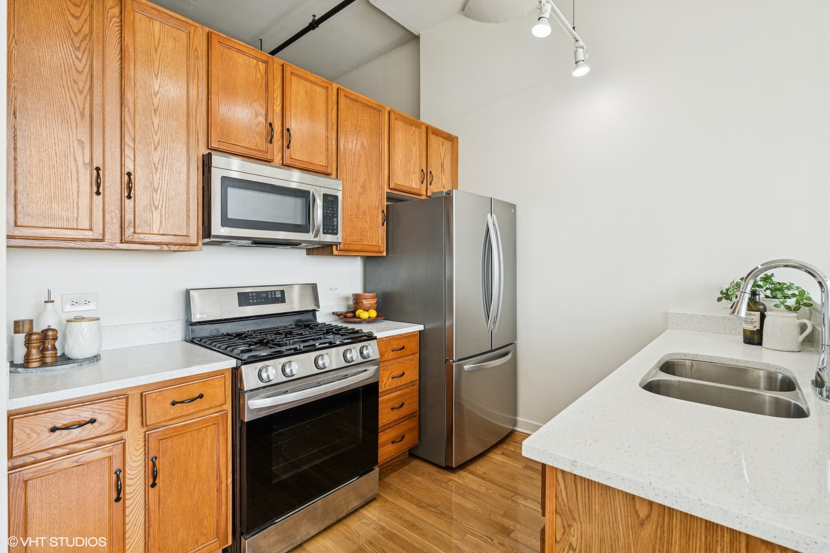 1224 West Van Buren Street, Unit 502 Chicago, IL 60607 - Photo 2 of 3 a kitchen with stainless steel appliances a stove a sink a refrigerator white cabinets and wooden floor