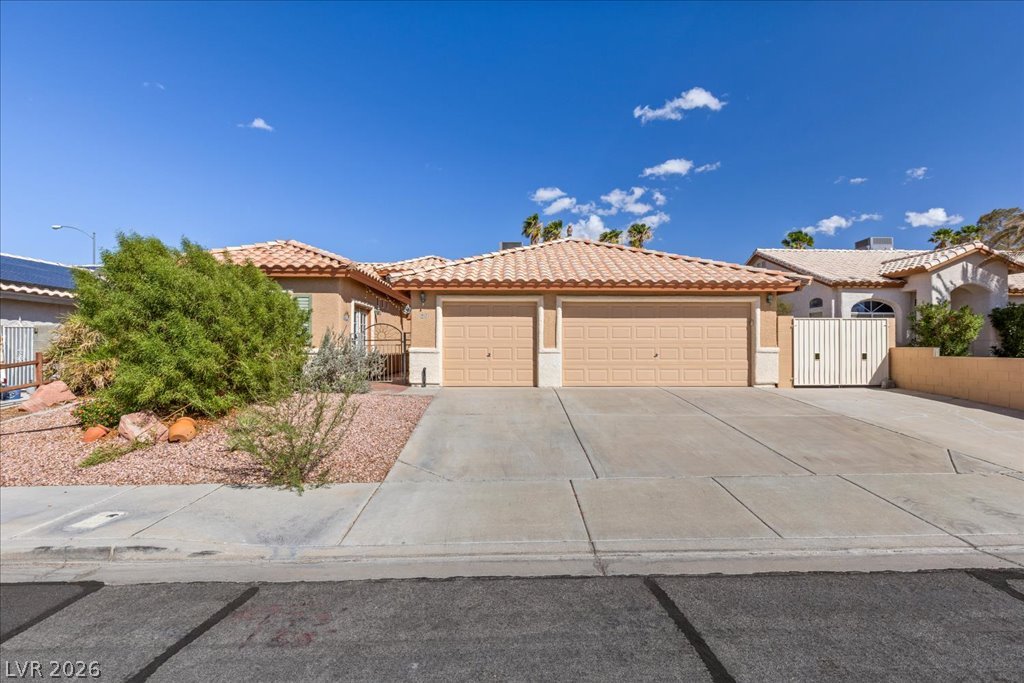 120 Ringlore Road Henderson, NV 89015 - Photo 2 of 58 Spanish tile roofing and a concrete driveway define this classic suburban exterior.