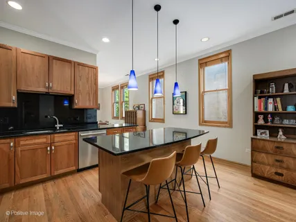 a kitchen with stainless steel appliances granite countertop a kitchen island a stove and a wooden floors