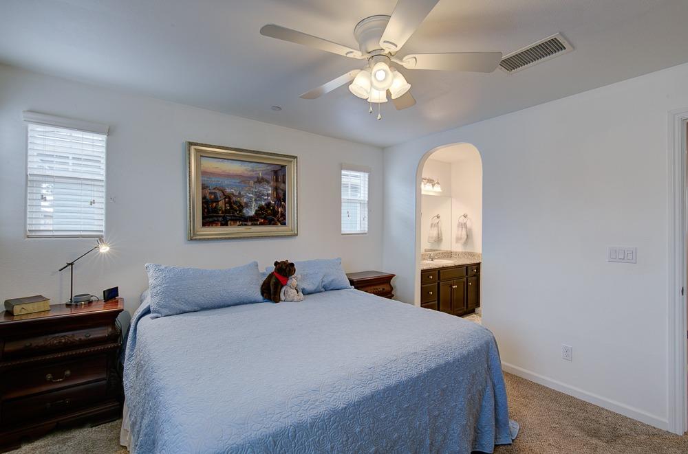 1530 Nabors Drive Clovis, CA 93619 - Photo 14 of 27 a bedroom with a large bed and a chandelier