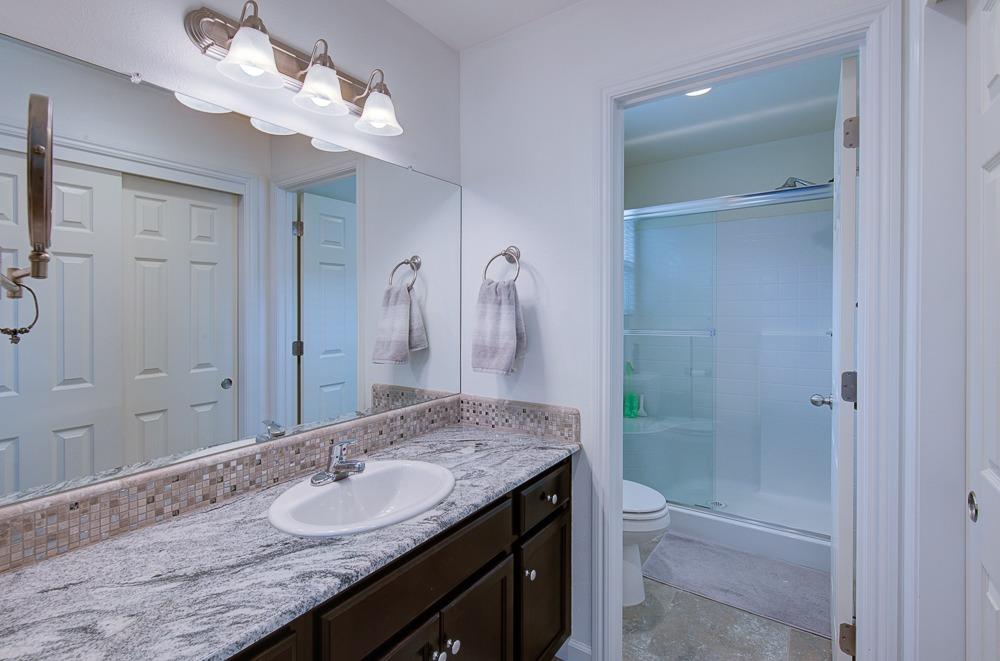1530 Nabors Drive Clovis, CA 93619 - Photo 15 of 27 a bathroom with a granite countertop sink a toilet and shower