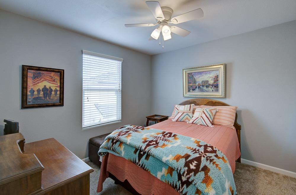 1530 Nabors Drive Clovis, CA 93619 - Photo 17 of 27 a bedroom with a bed and a chandelier