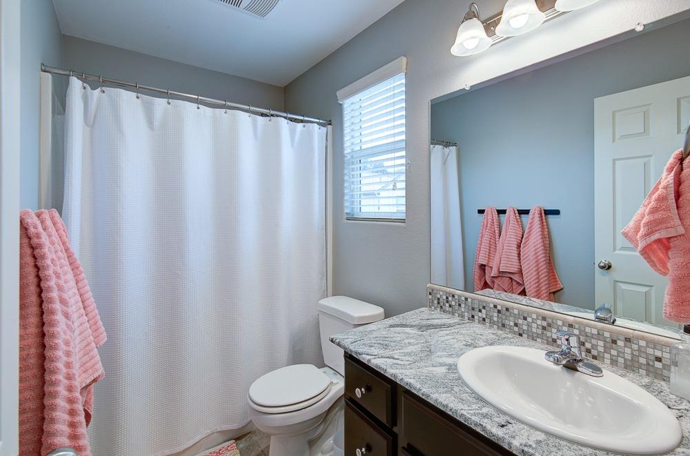 1530 Nabors Drive Clovis, CA 93619 - Photo 18 of 27 a bathroom with a granite countertop sink and a mirror