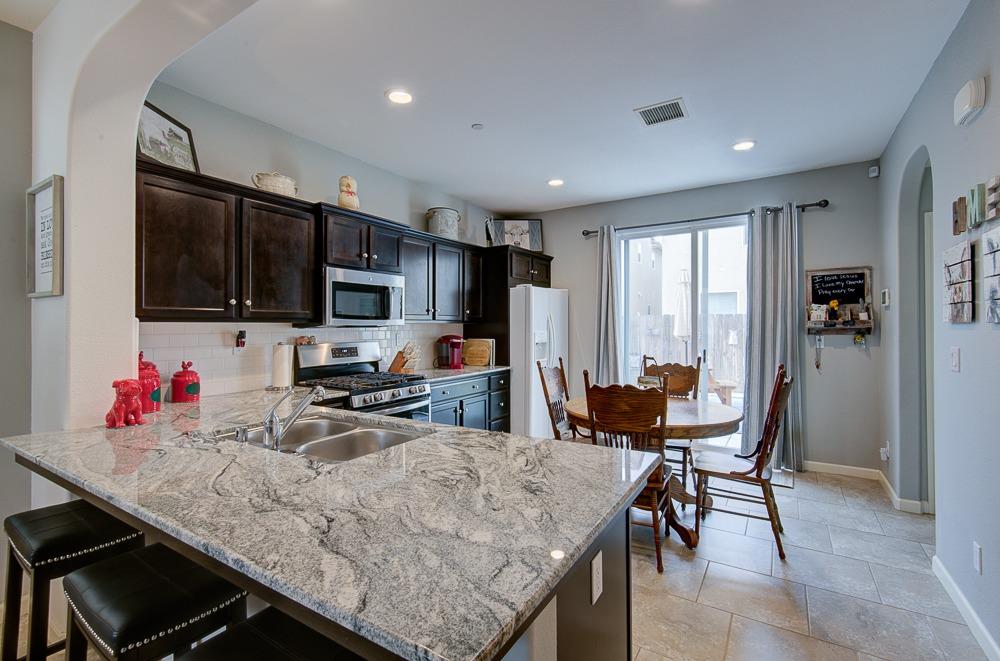 1530 Nabors Drive Clovis, CA 93619 - Photo 7 of 27 a kitchen with granite countertop lots of counter top space and stainless steel appliances